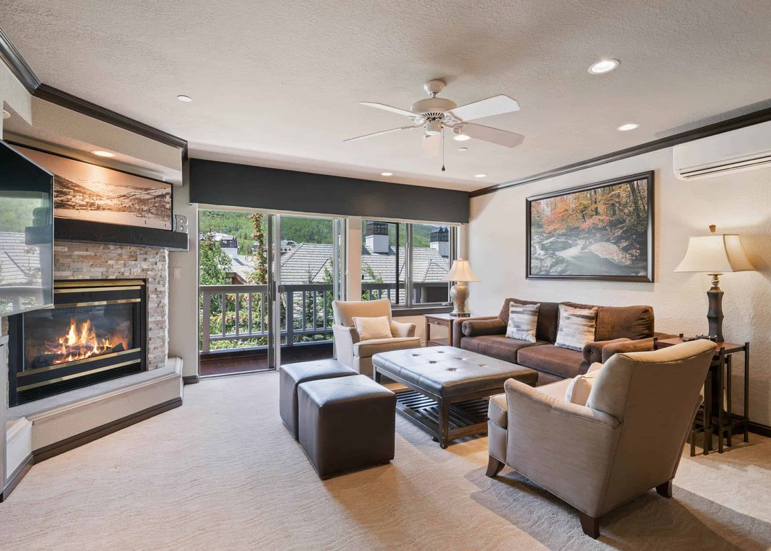 Living area in St James Place 121 with a cozy fireplace and balcony access.