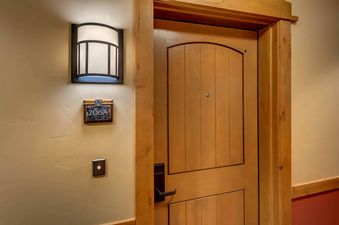 A wooden door with a metal door handle and a peephole. The door is labeled with the number 206A.
