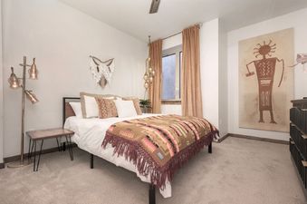 A cozy bedroom with a comfortable bed, warm lighting, and unique decor.