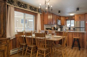 The dining area and kitchen of Beaver Village 1514 are visible, featuring wooden furniture and appliances.