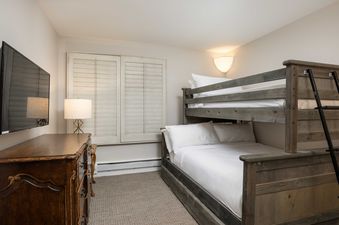Cozy bedroom in Montaneros 410 with bunk beds and rustic wood accents.