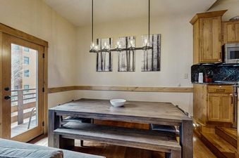 The dining area in Kutuk 211 featuring a rustic wooden table with bench seating and a modern hanging light fixture.