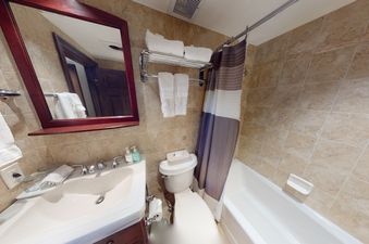 A white bathroom with a tub, toilet, sink, and shower.