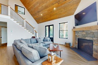 The living area in We Will Ski features a stone fireplace and comfortable seating.