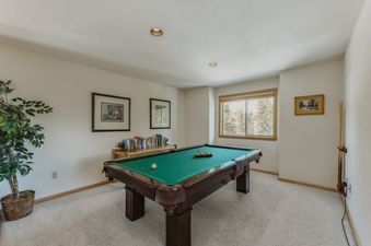 A billiards room featuring a pool table with a green felt surface.