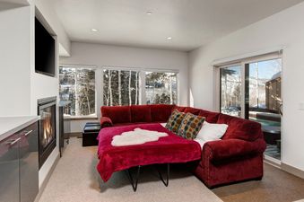 The living area of Abode at Little Belle 3 features a sleeper sofa and fireplace.