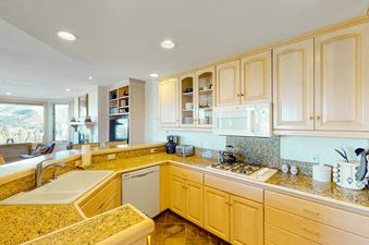 The kitchen at Lorian 14 has wood cabinets, granite countertops, and stainless steel appliances.