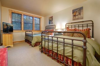 Cozy bedroom with two queen beds and rustic iron frames at Granite Ridge Homestead 3072.