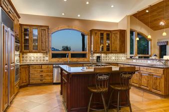 Warmly lit kitchen with wooden cabinets and a central island at Sweetwater Jackson Hole.