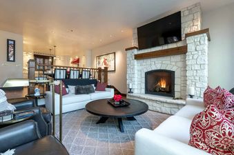 A living room with a fireplace, a white couch, and a coffee table.