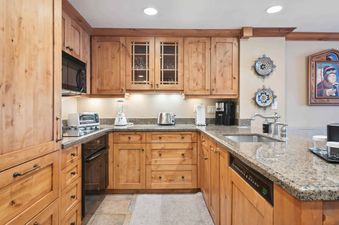 The beautifully appointed kitchen in Lodge Tower 294 features granite countertops and custom cabinetry.