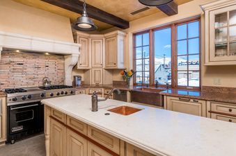 A kitchen with white cabinets, stainless steel appliances, and a copper sink.