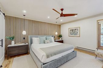 Modern and elegant bedroom at Kutuk 108 with a king bed, wood slat accent wall, and chic lighting.