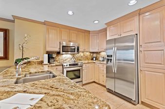The well-equipped kitchen at Lodge Tower 478 2BR features stainless steel appliances and granite countertops.