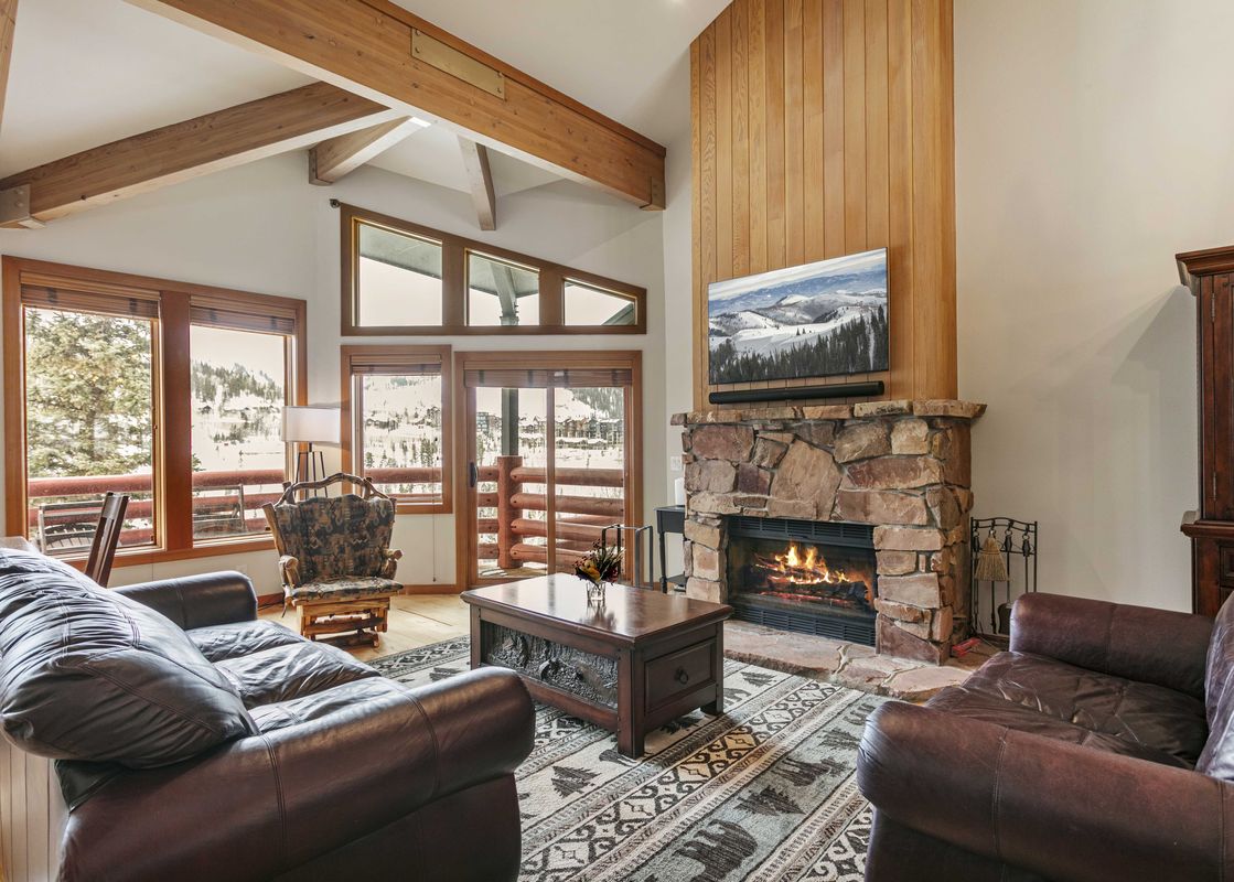 Enclave 11 living room with stone fireplace and leather furniture.