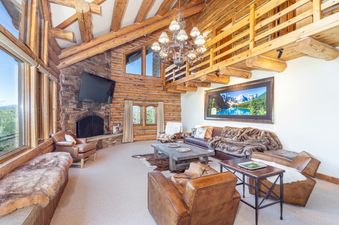 Spacious living room at 267 Country Club featuring a stone fireplace and luxurious leather furniture.