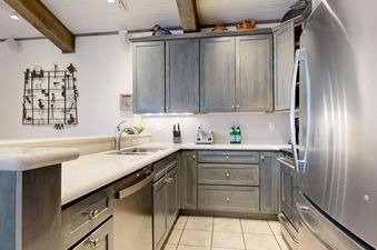 A modern kitchen with gray cabinets and stainless steel appliances in Top of the Village Leaf 503.