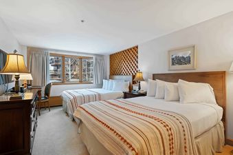 The bedroom at Lodge Tower 387 3BR, featuring two comfortable beds, a desk, and a window with a winter view.