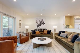 Comfortable living room with plush sofas, leather armchairs, and a large plaid rug in Windriver 2.