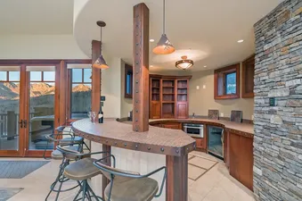 Two Trails features a built-in bar with bar stools and a wine bottle on the counter.