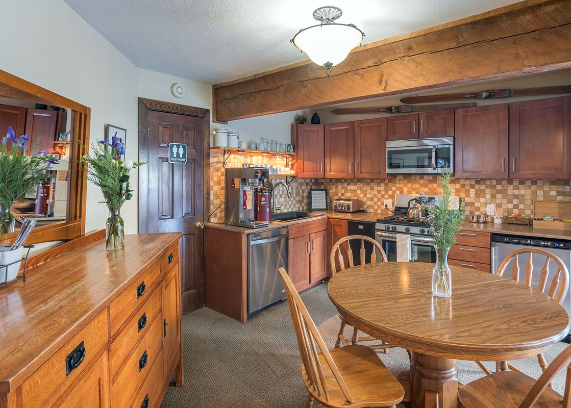 The kitchen and dining area at Manitou Lodge 9 features warm wood tones and plenty of natural light.