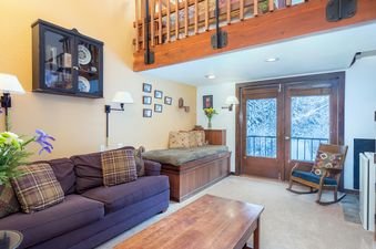 Living area in Manitou Lodge 6 with comfortable seating and a view to the outdoors.