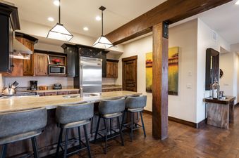 A well-appointed kitchen in Silver Star 4201 featuring dark wooden cabinetry, granite countertops, and stainless steel appliances.
