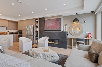 The spacious living area of Vail Spa 508 with a large modern fireplace, two armchairs, and a large sectional sofa, perfect for relaxing after a day of skiing.