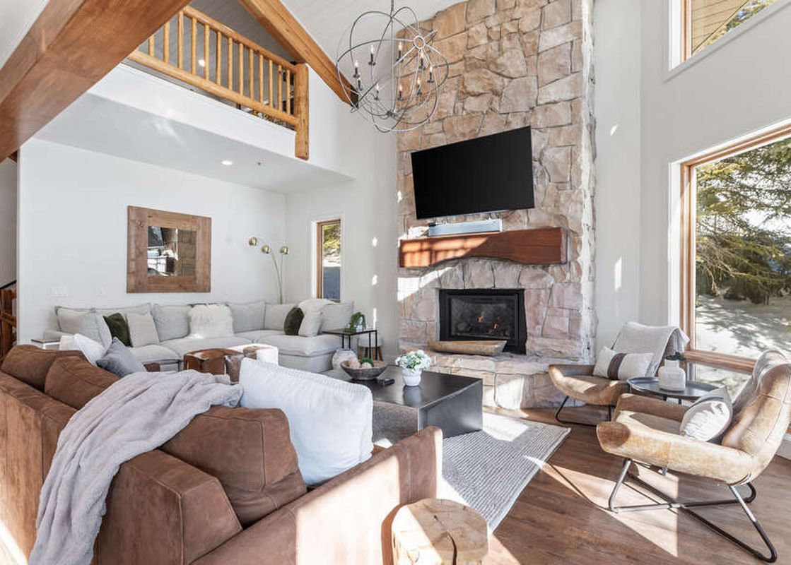 A living room with two sofas and a stone fireplace at Abode at Sterling Lodge.