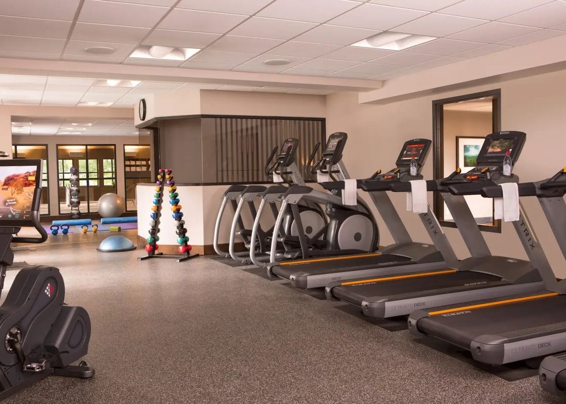 A modern fitness center at Teton Mountain Lodge and Spa Lodge Two Queens with treadmills, ellipticals, and weights.