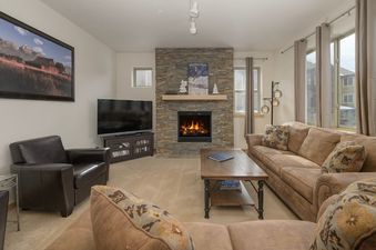 The inviting living area of Trailhead Lodges 422, featuring a warm fireplace, a comfortable sofa, and a large flat-screen TV.