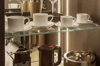 A modern mini bar setup in The Grand Teton Suite features an espresso machine, electric kettle, cocktail shakers, martini glasses, and espresso cups.