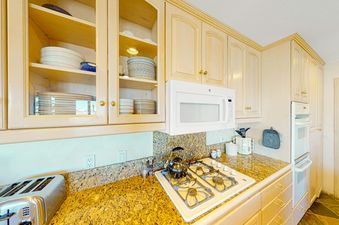 The kitchen in Lorian 14 has stainless steel appliances, a granite countertop, and a gas stove.