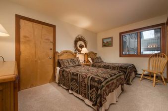 Cozy bedroom in Nez Perce C4 featuring two twin beds with Southwestern-patterned bedding and wooden furniture.