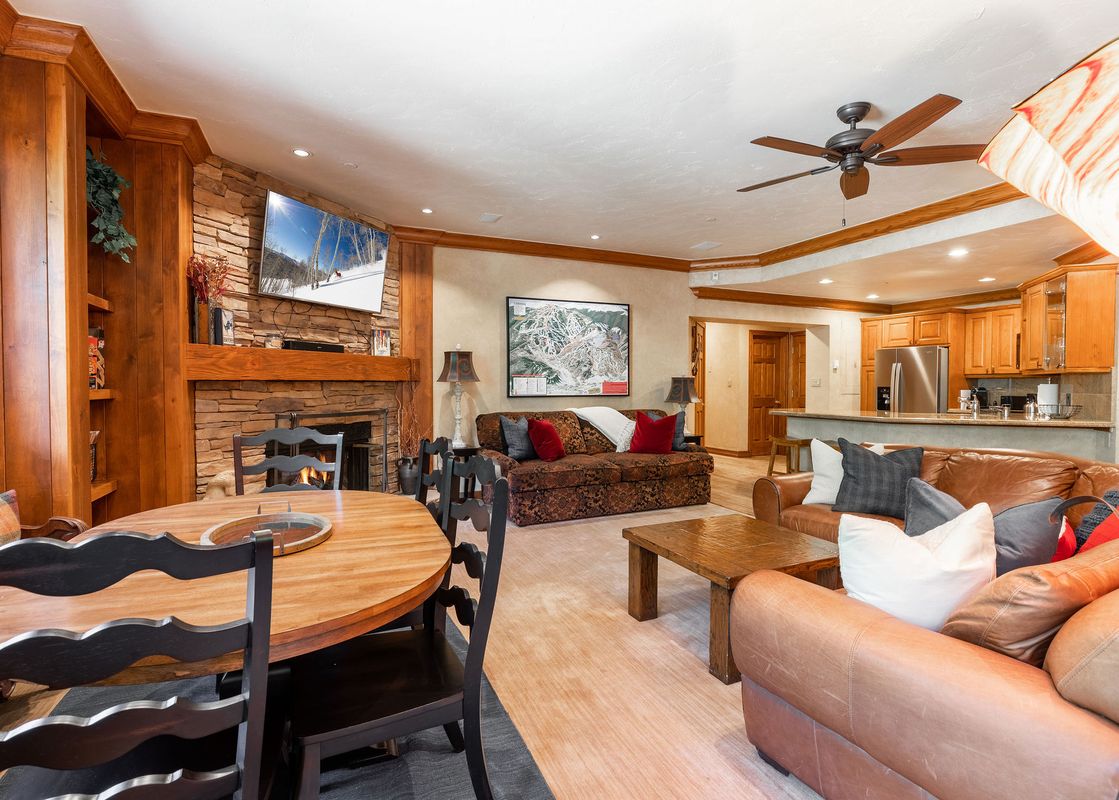 A living room with a fireplace, a dining room table, and a couch.