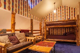 A rustic lounge area in Kutuk 201 with wood furniture, patterned textiles, and a bunk bed, creating a cozy and inviting atmosphere.