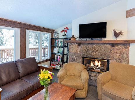 The inviting living area of Manitou Lodge 11 features a stone fireplace and comfortable seating.