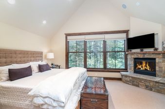 A bedroom in Trails Edge 5 featuring a fireplace and a large window.