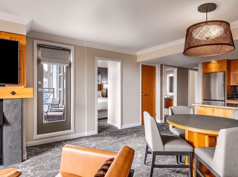 A spacious and elegantly furnished living area inside The Westin Resort Two Bedroom Suite, featuring a comfortable seating arrangement, a dining table, a fireplace, and an adjoining kitchen area.