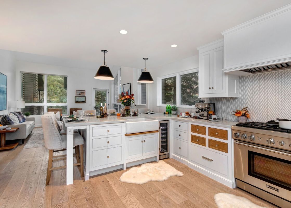 The Abode in Red Pine features a modern kitchen with white cabinets, stainless steel appliances, and hardwood floors.