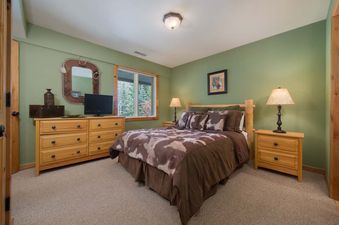 Cozy bedroom with green walls, a queen bed, and rustic wooden furniture at Whiteridge B3.