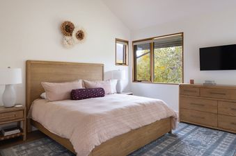 Cozy bedroom with wooden furniture and pink bedding at Mountain Momma.
