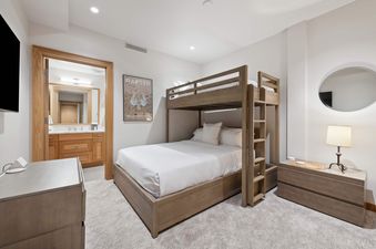 Riverfront Lodge 401 features a bunk bed with a wooden ladder and a dresser