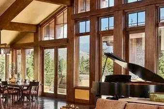 Living room of the Ski Vista Penthouse featuring a grand piano and large windows.