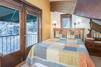 Manitou Lodge 7 bedroom with balcony overlooking snowy landscape.
