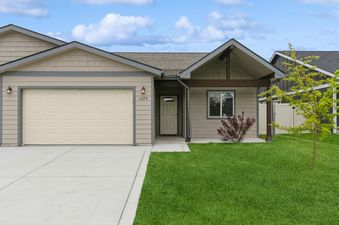 The Destiny Cove unit presents a modern and inviting exterior, featuring a cream-colored garage door, light beige siding, and a neatly manicured lawn.