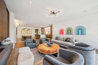 The Founders Place 2405 living area showcases an open-concept design with a living room, dining area, and kitchen, all featuring modern furnishings and vibrant art.