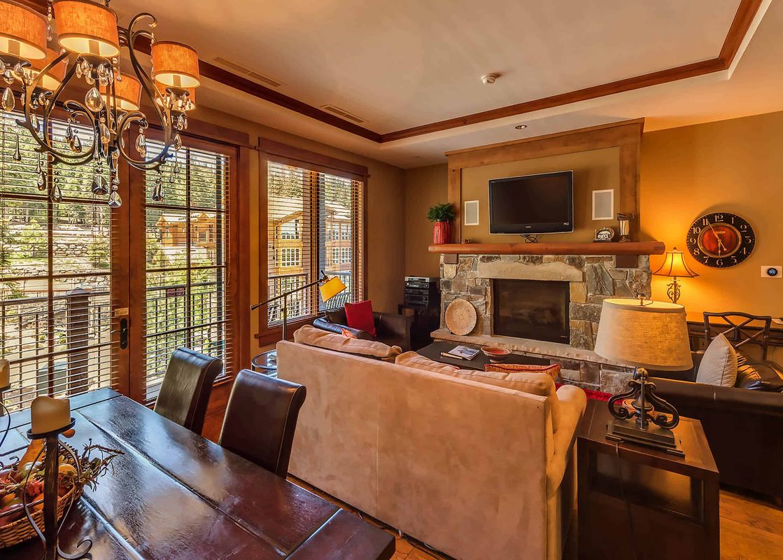 A spacious living room with a fireplace and a dining table