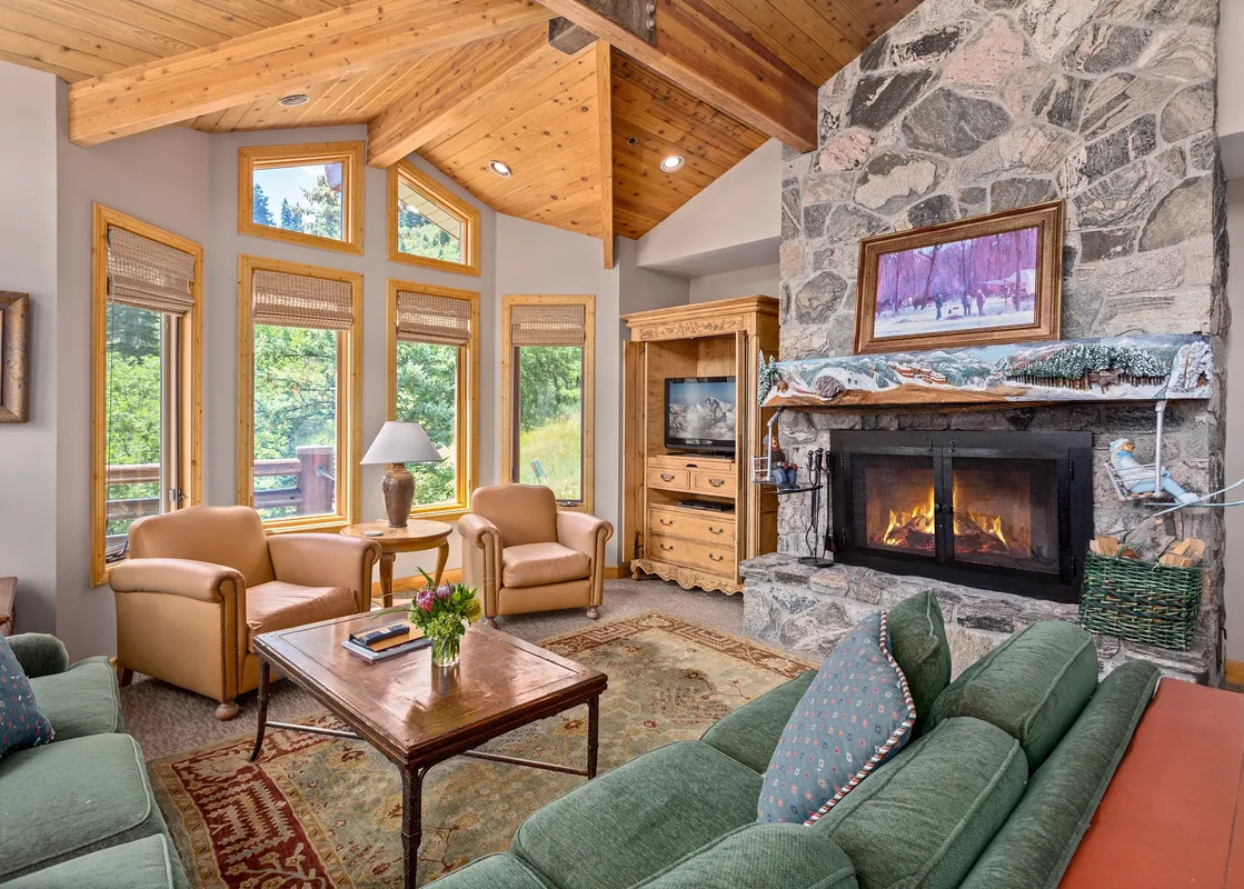 Trails End Lodge 18 features a large living room with a fireplace and a stunning view.