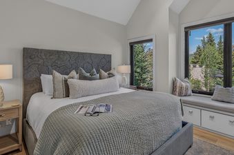 Luxurious primary bedroom at Moose Meadows Reserve with a custom headboard, king bed, and scenic window views.